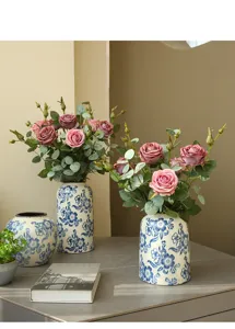 Artificial rose flower arrangement in blue and white ceramic vase for home decor interior.