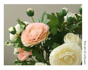 Close-up detail of artificial pink and white ranunculus flower bouquet with lush green leaves.