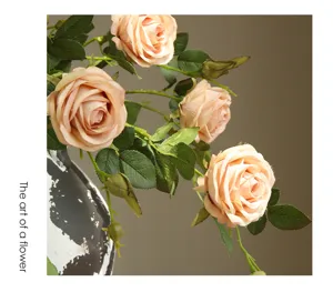 Artificial rose flower detail shot showcasing realistic petals and lush green leaves.