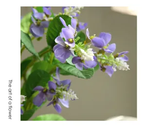 Primer plano de una rama de flor de espuela violeta artificial, pétalos realistas para decoración.