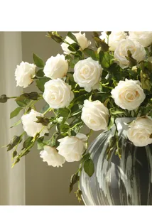 Detailed close-up of cream artificial roses bouquet in a textured vase for home decor.
