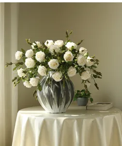 Artificial white rose bouquet in stylish black and white ceramic vase for elegant home decor.