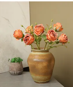 Detailed view of retro artificial orange roses in a ceramic vase, perfect for home decor.