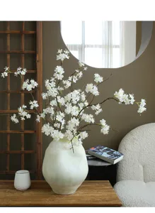 Detailed view of artificial white snow ball flower arrangement in ceramic vase for home decor.