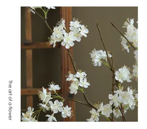 Detailed close-up of artificial white snowball flower branch for home decor and tabletop display.