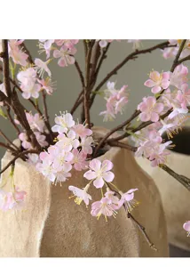Close-up detail of artificial pink cherry blossom flower branch, exquisite home decor arrangement.