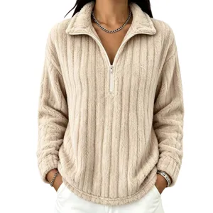 Dettaglio di una morbida felpa in pile a coste con mezza zip in una raffinata tonalità beige.