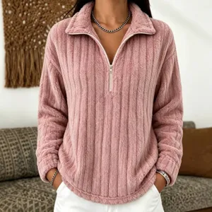 Dettaglio di pullover rosa in morbida felpa peluche a coste con zip e colletto alto.