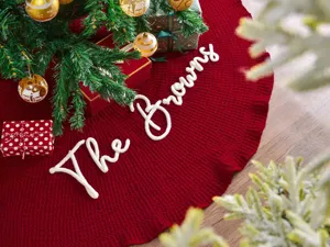 Detalle de falda de árbol de Navidad roja tejida, alfombra decorativa festiva para el hogar.