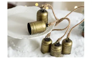 Rustic metal Christmas hanging bells with jute rope, vintage holiday tree decoration props.