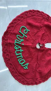 Primer plano detallado del árbol de Navidad rojo de punto con letras verdes bordadas.