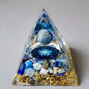 Detail view of crystal resin pyramid with blue stones and sacred geometry interior.