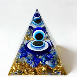 Close up detail of clear resin orgonite pyramid with gold foil and lapis lazuli evil eye chips.