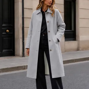 Vue détaillée d'un élégant trench-coat mi-long gris clair pour femme avec revers et boutons.