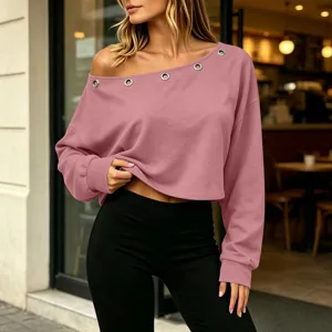 Detail view of the pink off-shoulder long sleeve crop top with metal eyelets and black leggings.