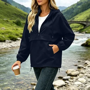 Detailed view of women's navy blue hooded quarter-zip windbreaker jacket outdoors.