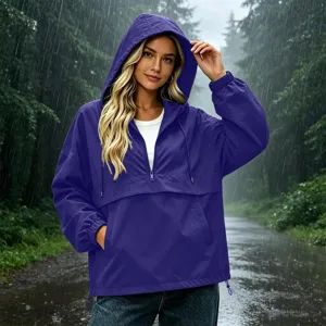 Detail shot of women's waterproof hooded anorak jacket in rain forest setting, casual.