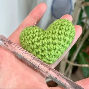 Vue détaillée de la boucle d'oreille cœur au crochet montrant la taille et l'artisanat.