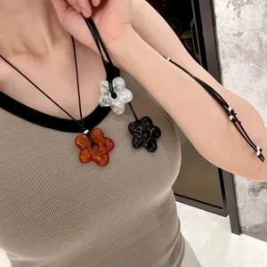 Korean style minimalist hollow flower long necklace with black cord and chic pendant.