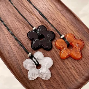 Detailed view of Korean style minimalist hollow flower pendant sweater chain, chic accessory.