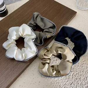 Detailed shot of vintage French style hair scrunchies with chic edge trim in multiple colors.