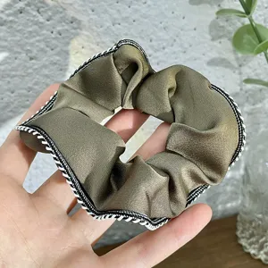 Close-up detail of retro satin hair scrunchie with elegant lace edge, daily hair accessory.