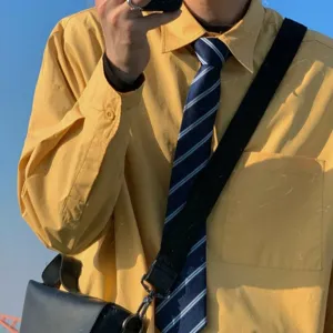 Camisa de manga larga amarilla estilo universitario con corbata de rayas azules moda mujer.