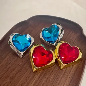 Close-up view of vintage crystal heart earrings showing detailed metal frames and sparkling stones.
