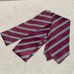 Vista detallada de la elegante corbata burdeos con clásicos patrones de rayas diagonales diarios.