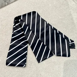 Detalle en primer plano de una corbata delgada clásica con rayas diagonales blancas.