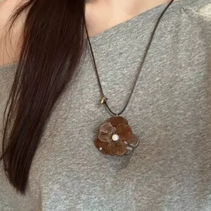 Chic leopard print flower pendant necklace with pearl center and brown cord for women.