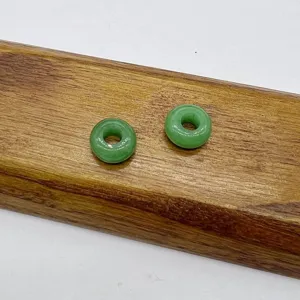 Green jadeite donut beads detail shot, smooth polish texture, perfect for DIY jewelry making accessories.