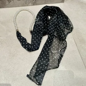 Black polka dot chiffon scarf with pearl necklace detail, French rose print streamer ribbon.