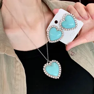 Ensemble collier et boucles d'oreilles cœur strass bleu, détail chaîne pull vintage.