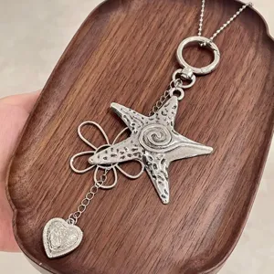 Close-up detail of silver metal star flower pendant necklace, Y2K aesthetic accessory.