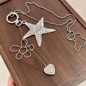 Y2K style silver star flower heart pendant necklace detailed view, grunge aesthetic jewelry.