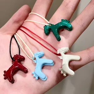 Detailed view of colorful enamel little horse pendants, cute toy-style charms with ropes.