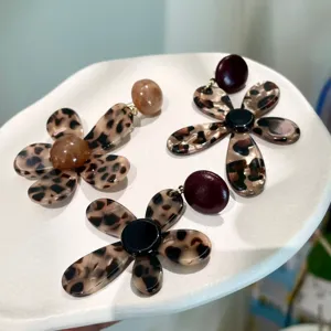 Detailed close-up shot of trendy leopard print flower earrings with glossy acrylic design.