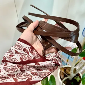 Vue détaillée ceinture fine femme cuir marron avec accessoire foulard soie cachemire bordeaux.