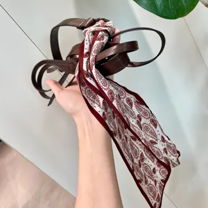 Vue détaillée de l'élégante ceinture pour femme en cuir marron et foulard en soie paisley vintage.