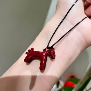 Closeup view of a cute enamel little horse pendant necklace showcasing fine details and texture.