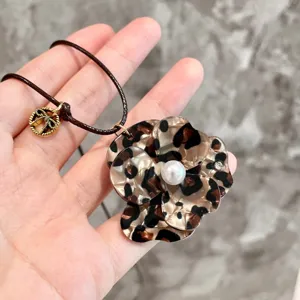 Close-up detail of the leopard print acrylic flower pendant with a central pearl accent.