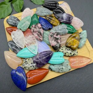 Detail view of colorful natural crystal heart pendants displayed on wooden board for DIY crafts.