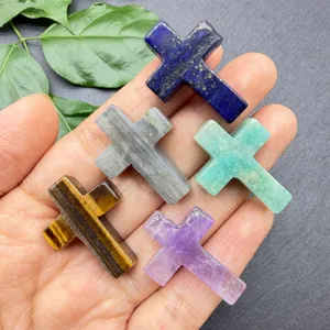 Detailopname van natuurlijke kristallen kruis hangers met diverse edelsteen texturen en kleuren.