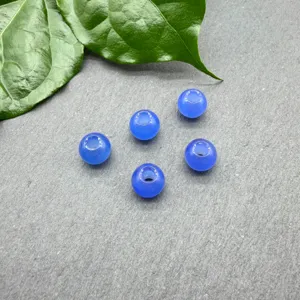 Primo piano di perline rotonde in pietra naturale blu da 8 mm su ardesia con foglia.