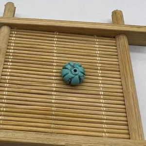 Close-up detail of natural turquoise flat pumpkin bead for DIY jewelry making and crafting.