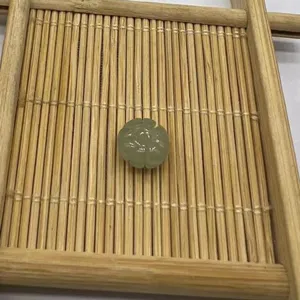 Detail shot of a carved gemstone pumpkin bead on a wooden tray, ideal for DIY jewelry making.