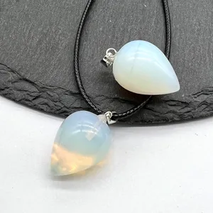 Close-up teardrop pendant detail with black cord, glowing gemstone finish, elegant jewelry.