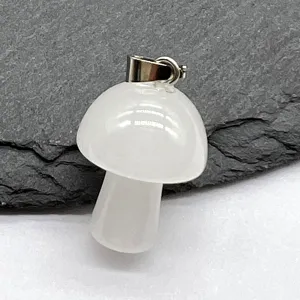 Close-up of a mini white crystal mushroom pendant with metal bail on slate detail view.