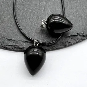 Teardrop black stone crystal pendant detail view, smooth polished gemstone necklace with silver bail.